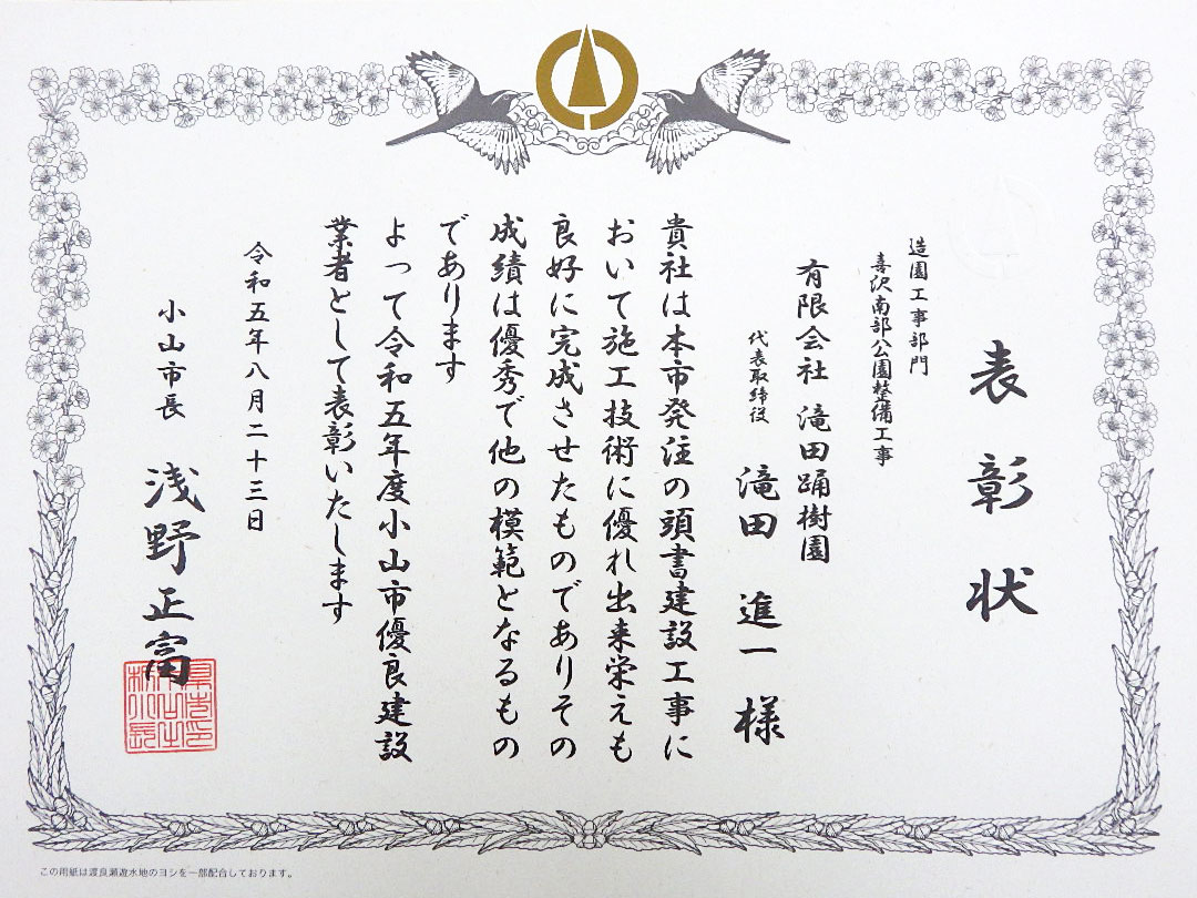 表彰状 造園工事部門 喜沢南部公園整備工事 有限会社滝田踊樹園 代表取締役滝田進一様 貴社は本市発注の頭書建設工事において施工技術に優れ出来栄えも良好に完成させたものでありその成績は優秀で他の模範となるものであります よって令和五年度小山市優良建設業者として表彰いたします 令和五年八月二十三日 小山市長 浅野正富